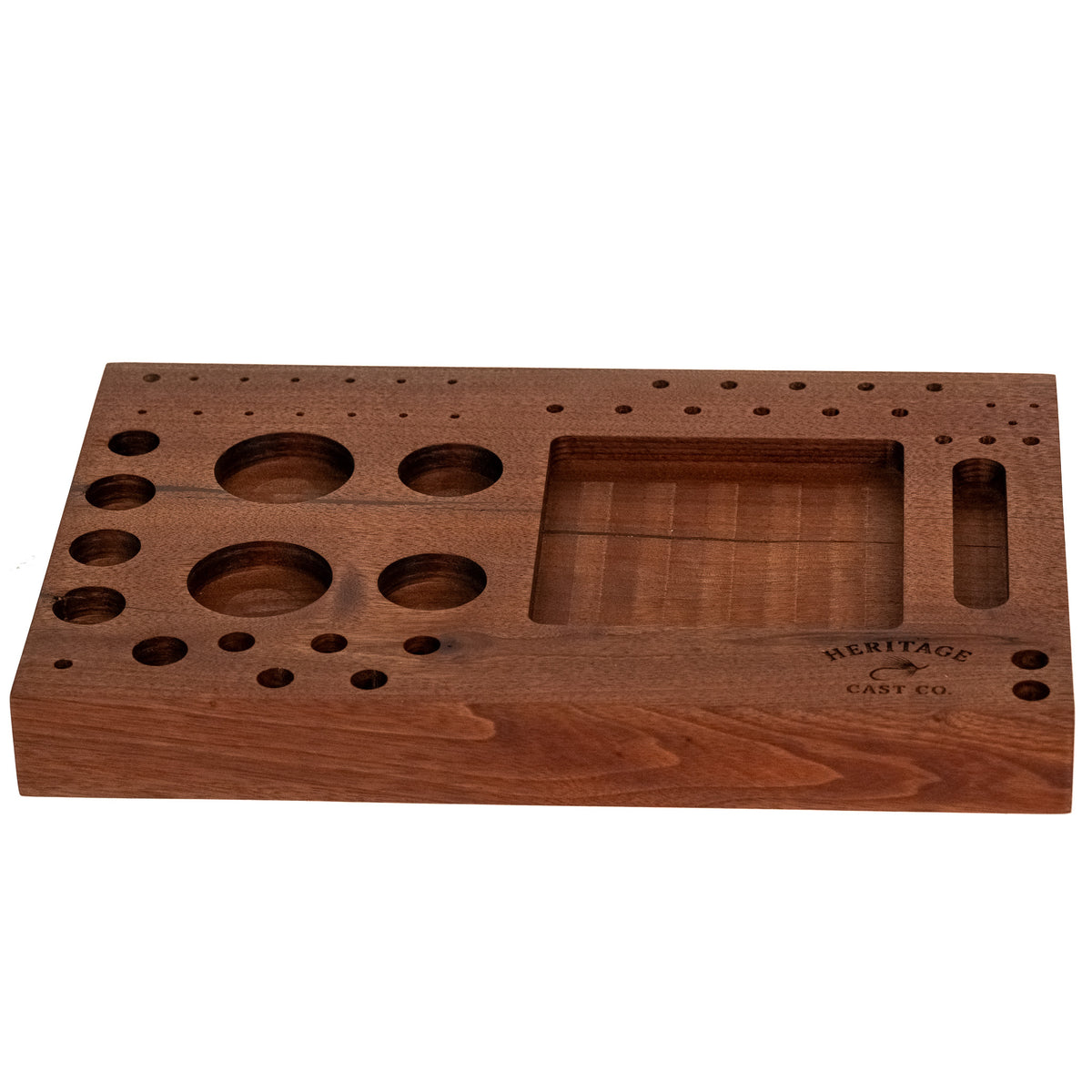 A rectangular wooden game board with multiple circular and rectangular cutouts, shown on a plain white background. The board has engraved text reading 'HERITAGE CAST CO.