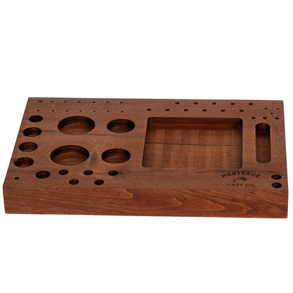 A rectangular wooden game board with multiple circular and rectangular cutouts, shown on a plain white background. The board has engraved text reading 'HERITAGE CAST CO.