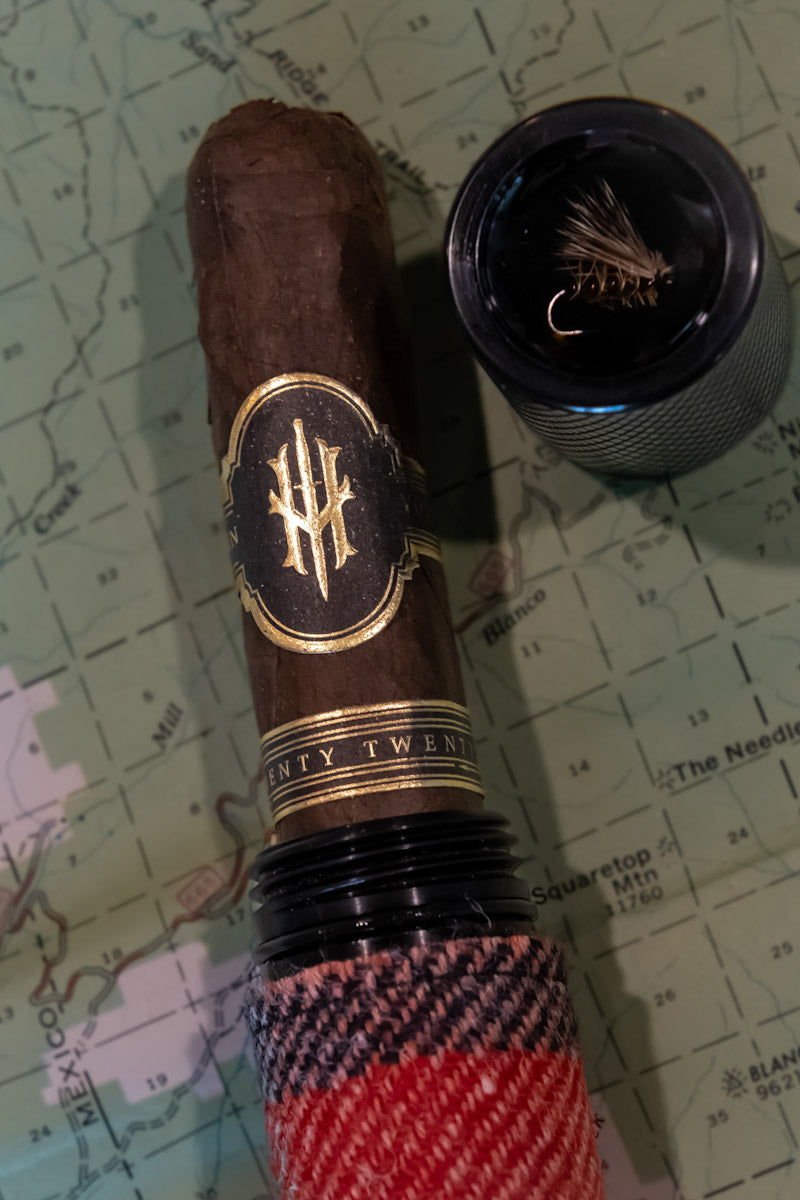Cigar with a branded band and checkered wrapper on a map background